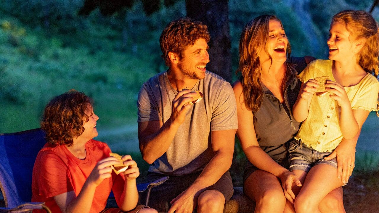 family enjoying hersheys smores outdoors by the campfire