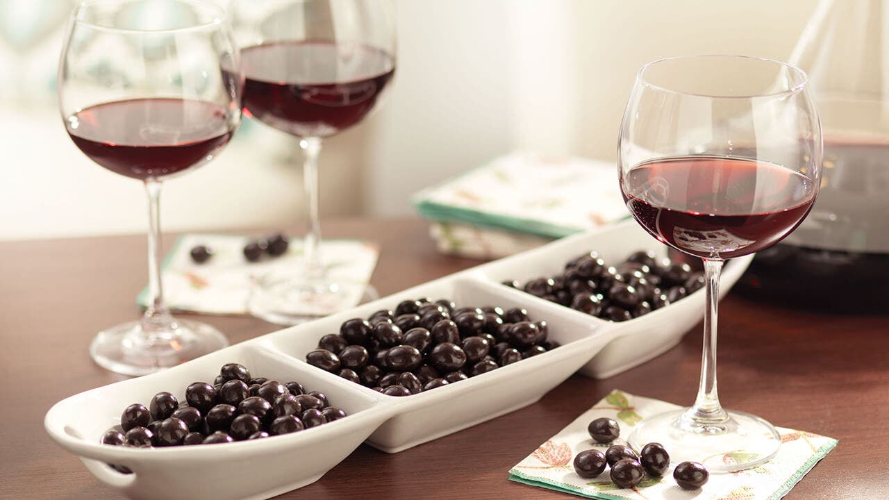 glasses of wine and brookside chocolates on wood table