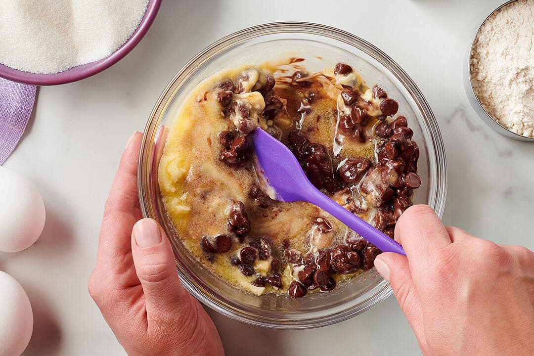 person mixing hersheys chocolate chips into batter