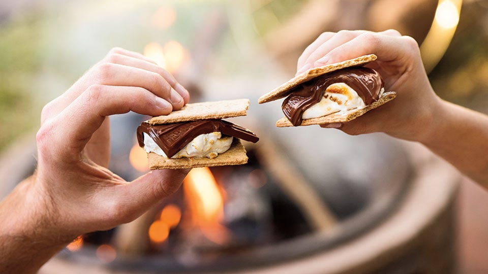 people enjoying smores around campfire