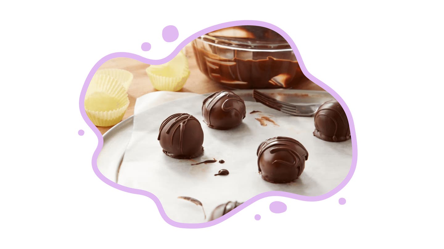 chocolate truffles drying on parchment paper after being dipped in chocolate coating